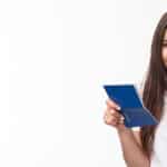 Quem Tem Direito ao Abono Salarial do PIS - PASEP? Travelling, holidays, summer concept. Close-up portrait of cute, happy pretty young woman in t-shirt, holding opened passport and smiling, standing in airport terminal going for journey, vacation