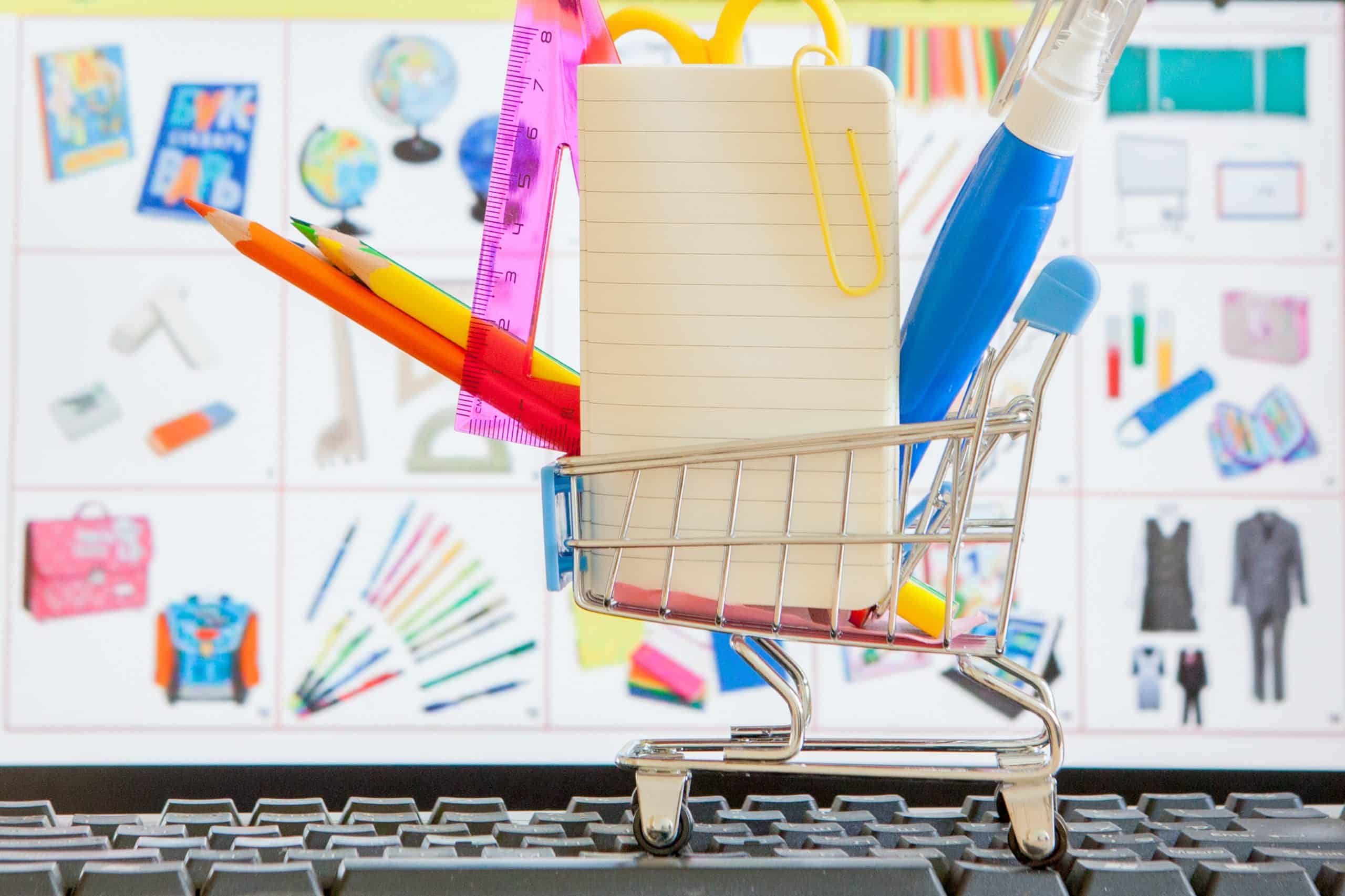 Shopping cart full of school tools on the keyboard, online shopping concept