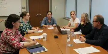 Parents and educators collaborating on an Individualized Education Program (IEP) in a school meeting.