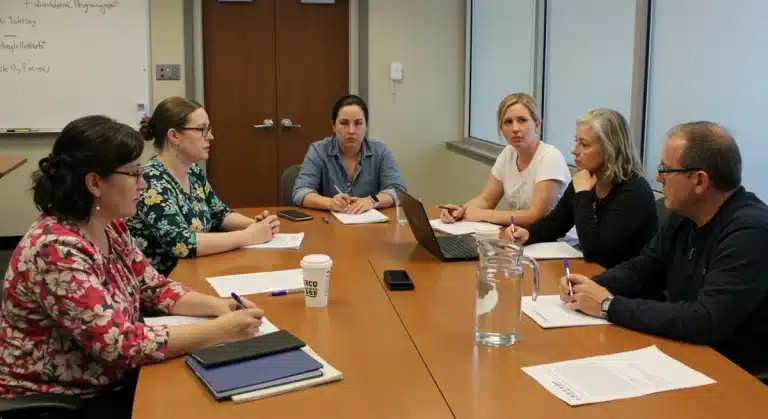 Parents and educators collaborating on an Individualized Education Program (IEP) in a school meeting.
